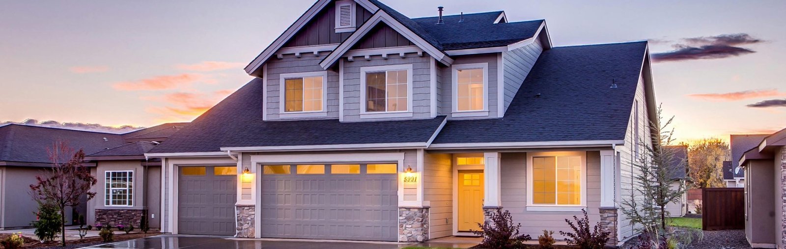 Elegant suburban home with driveway at sunset showcasing modern architecture.